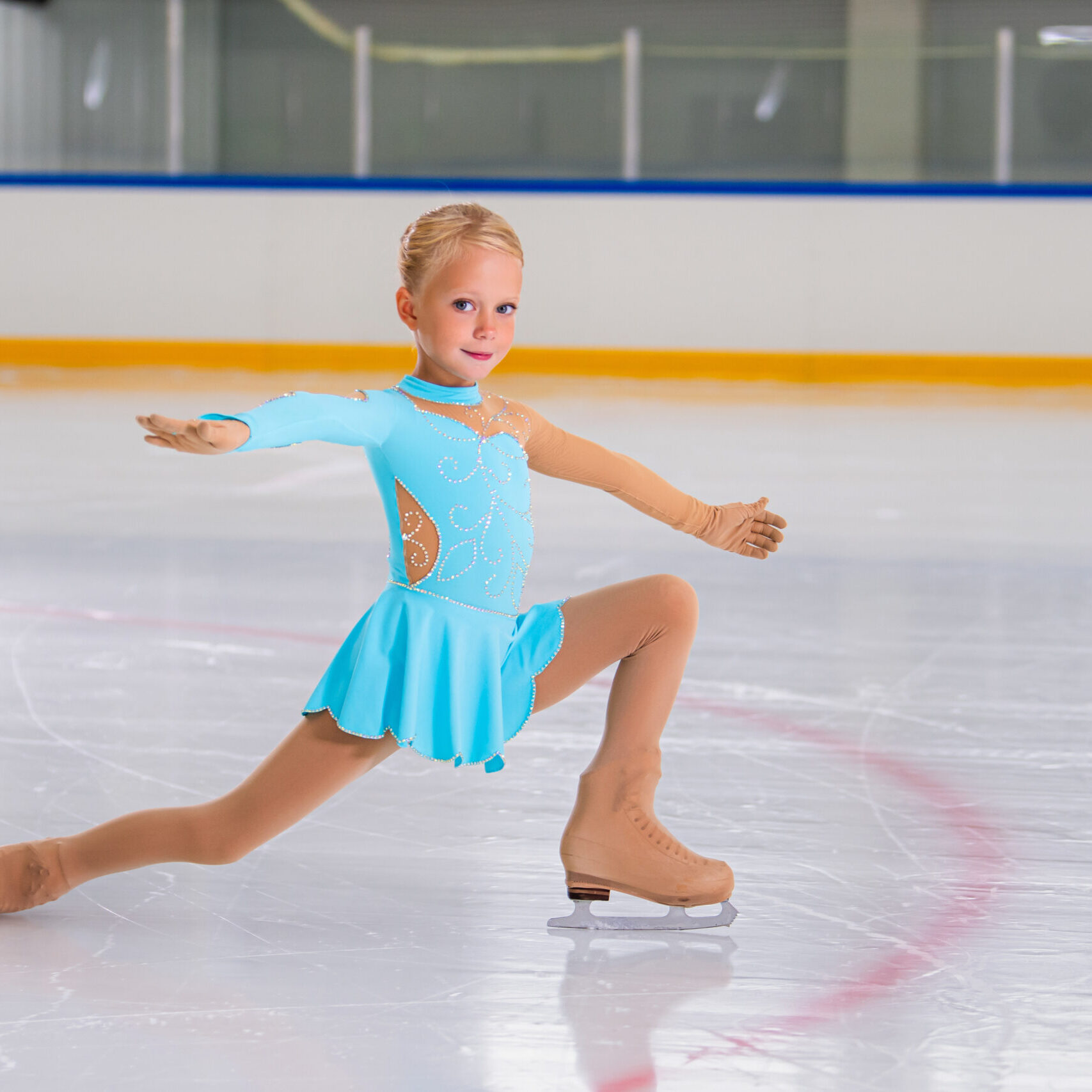 Full length portrait of little girl doing figure skating on indoor rink during performance Full length portrait of little girl doing figure skating on indoor rink during performance, copy space